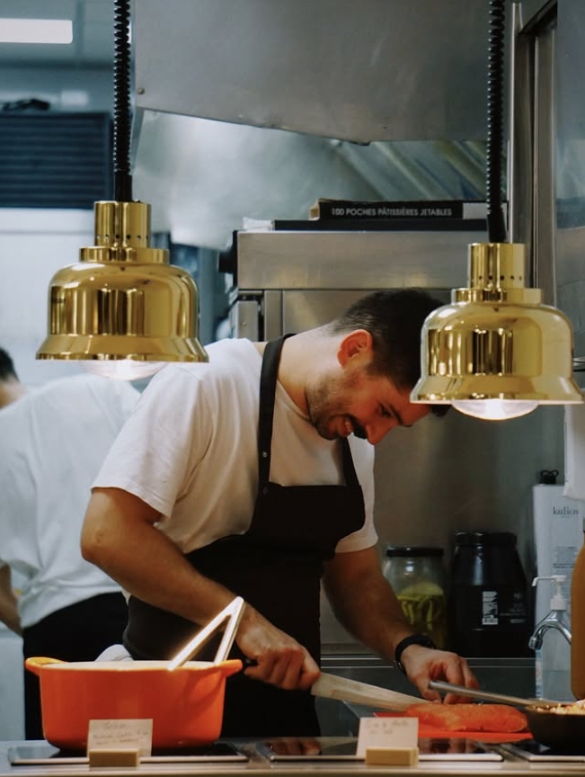 Le chef en cuisine sous les lampes chauffantes
